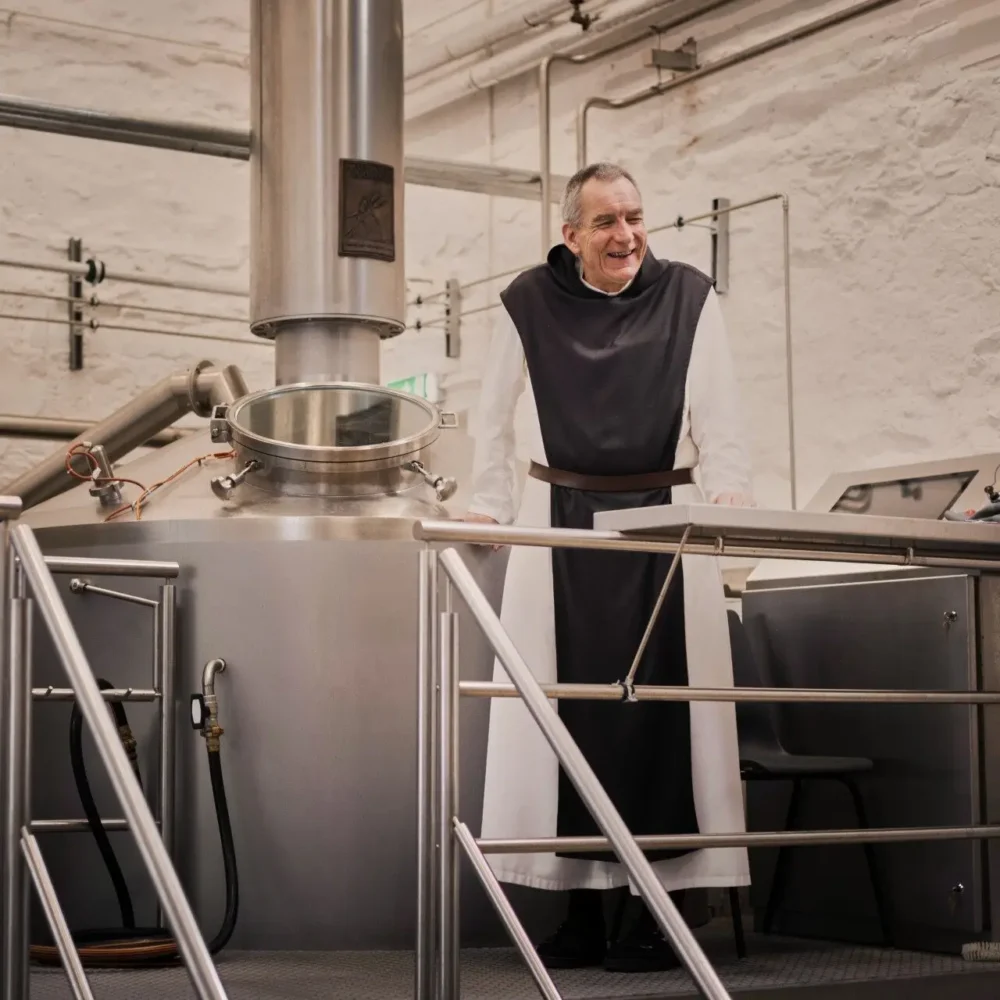 Monk of Mount St Bernard talking during brewery tour