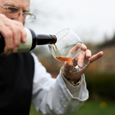 R01_9812 Trappist Monk carefully pouring bottle of Tynt Meadow